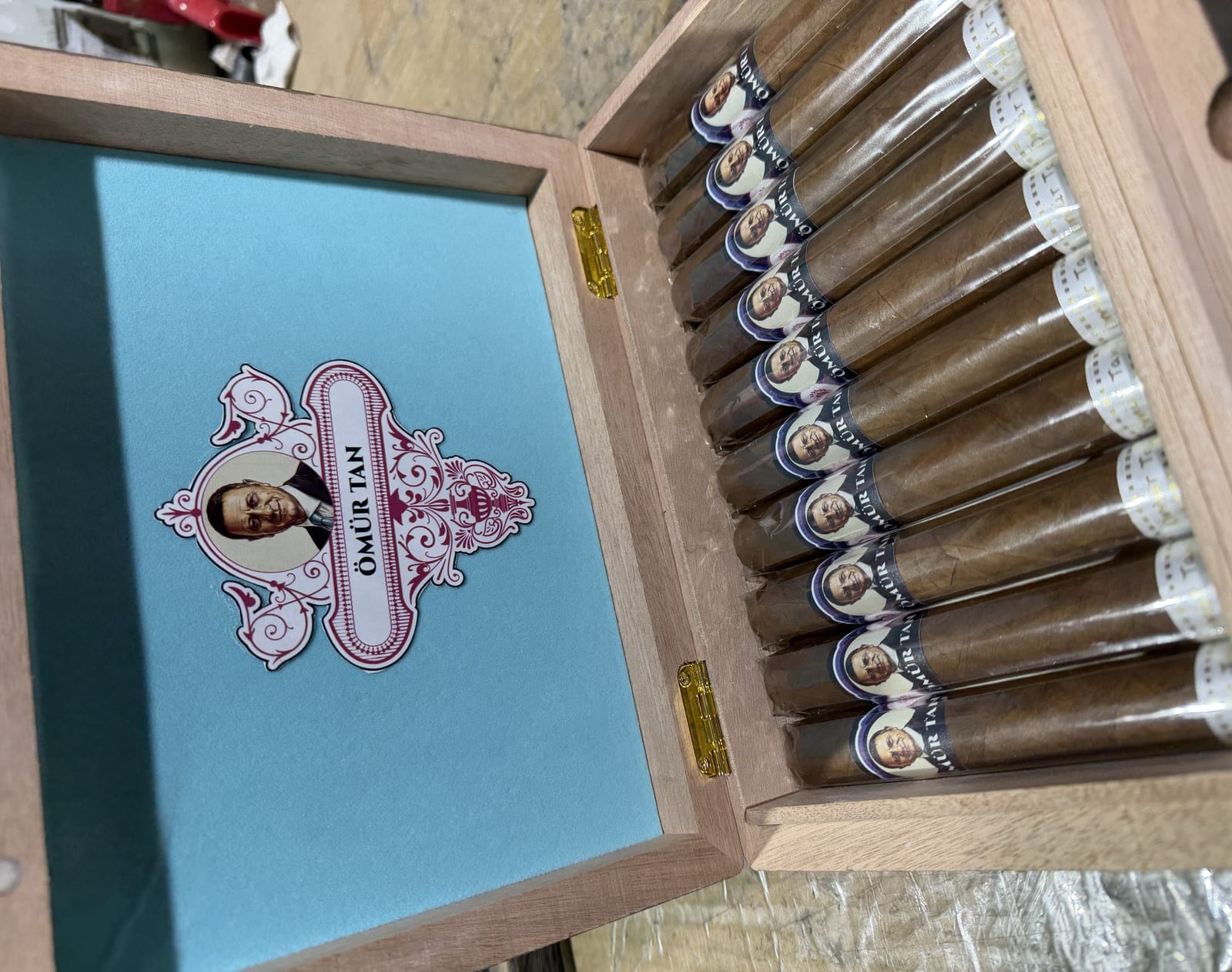 Ornate custom presentation box of wedding cigars with a crested lid on display